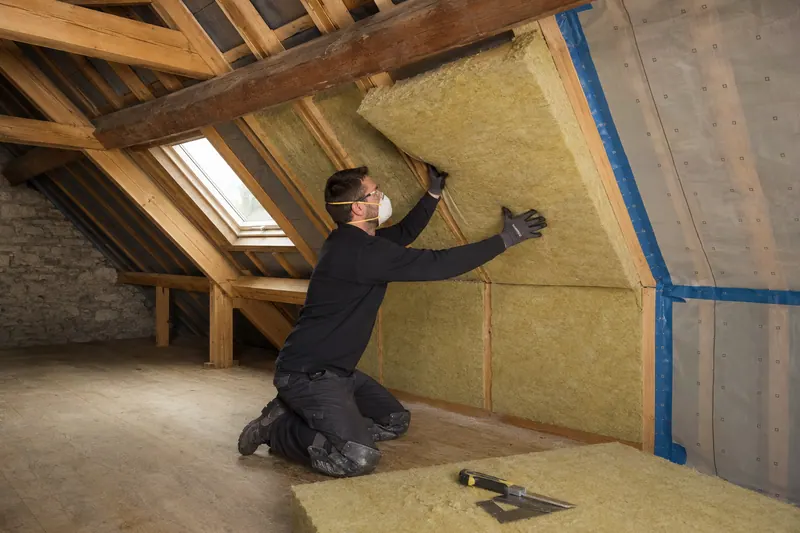 Professionnel posant l'isolation d'une toiture par l'intérieur des combles aménagés