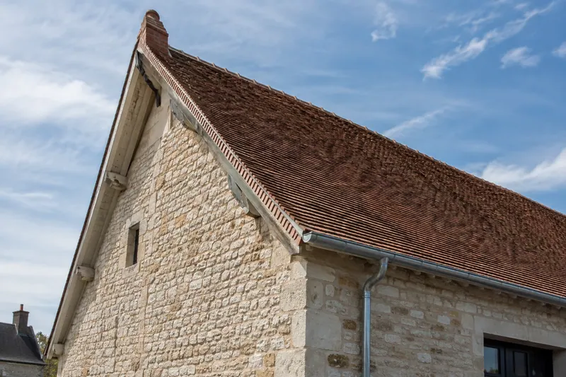 Toiture à deux versants marqués, pente forte typique d'une couverture en petits éléments