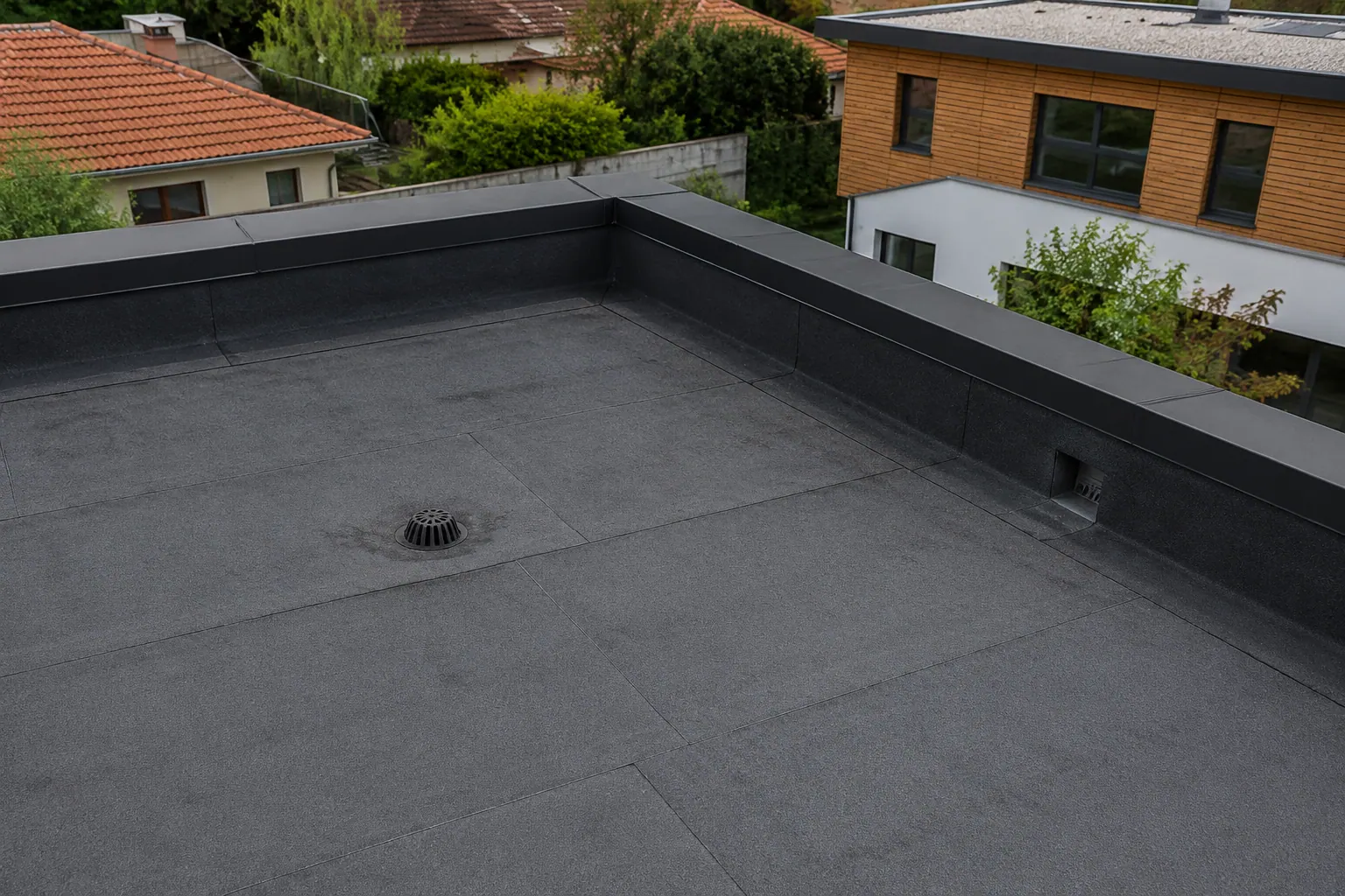Toiture-terrasse à étanchéité bitumineuse autoprotégée, relevés et évacuations visibles