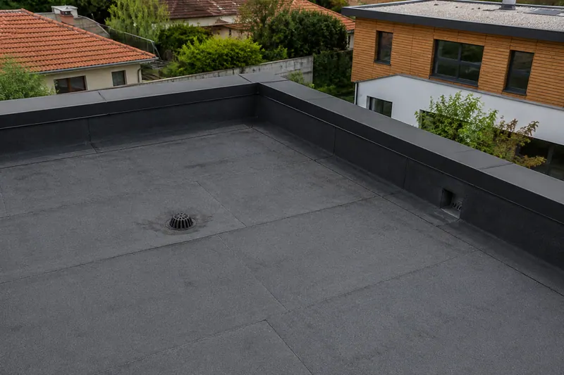 Toiture-terrasse à étanchéité bitumineuse autoprotégée, relevés et évacuations visibles